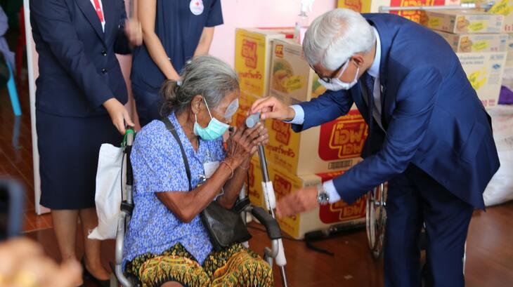 Le secrétaire général de l'IFRC, Jagan Chapagain, parle à une femme en fauteuil roulant et l'assiste dans une clinique ophtalmologique gérée par la Croix-Rouge thaïlandaise à Bangkok, où elle a reçu un soutien médical de la part du personnel et des volontaires, en septembre 2022.
